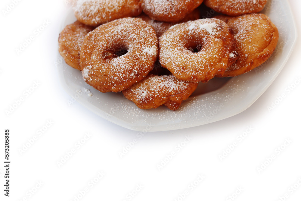 Homemade deep fried apple rings with batter sprinkled with powdered sugar on a  plate isolated on white backgrounds
