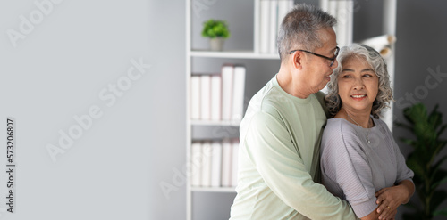 Happy senior adult  couple hugging, bonding their healthy relationship together in the living room.
