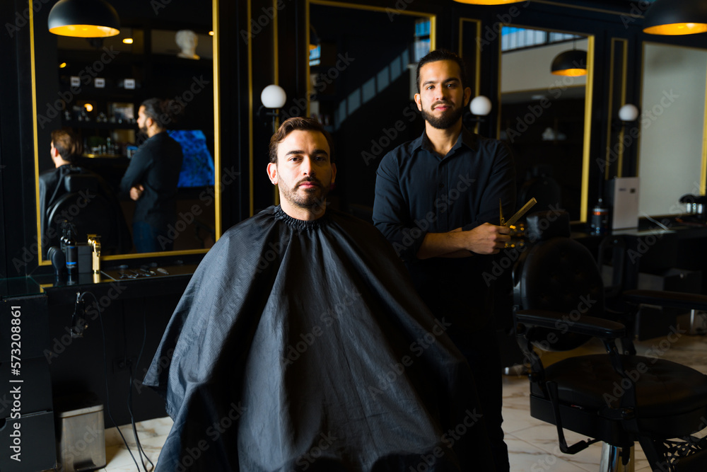 Male customer and barber at an elegant barber shop or salon Male customer and barber at an elegant barber shop or salon