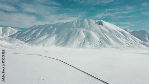 Italy, February 2023: aerial view from the drone of a winter and snowy landscape near castelluccio di Norcia in the province of Perugia in the Marche region photo