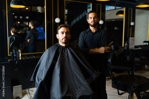 Male customer and barber at an elegant barber shop or salon