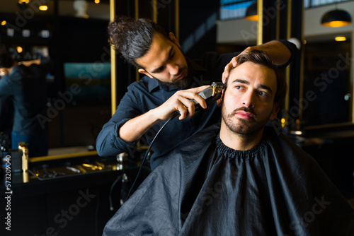 Young man getting a haircut from a barber
