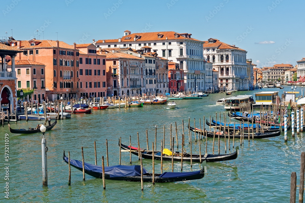 Picturesque view of Grand canal at Rialto Market with unique mixture of houses with different architecture style, gondolas, boats and water buses