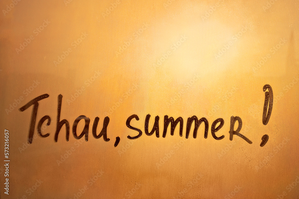 lettering Tchau in Portuguese language is bye in english and summer on foggy glass on sunset window