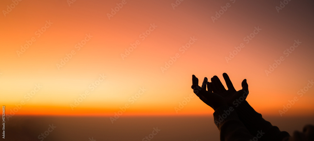 Silhouette of woman hand praying spirituality and religion, female worship to god. banner with copy space. Religious people are humble to God. Christians have hope faith and faith in god.