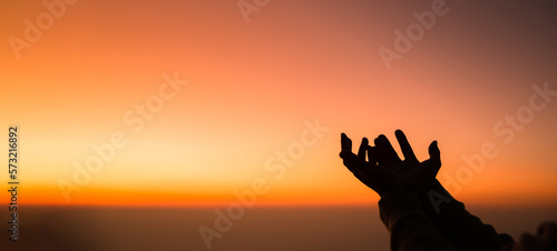 Silhouette of woman hand praying spirituality and religion, female worship to god. banner with copy space. Religious people are humble to God. Christians have hope faith and faith in god.