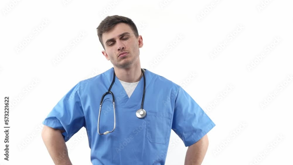 Portrait of a young medic in a blue uniform and with a stethoscope of good appearance keeps his hands on his belt. On a white isolated background. Portrait of a young medic in a blue uniform and with a stethoscope of good appearance keeps his hands on his belt. On a white isolated background.