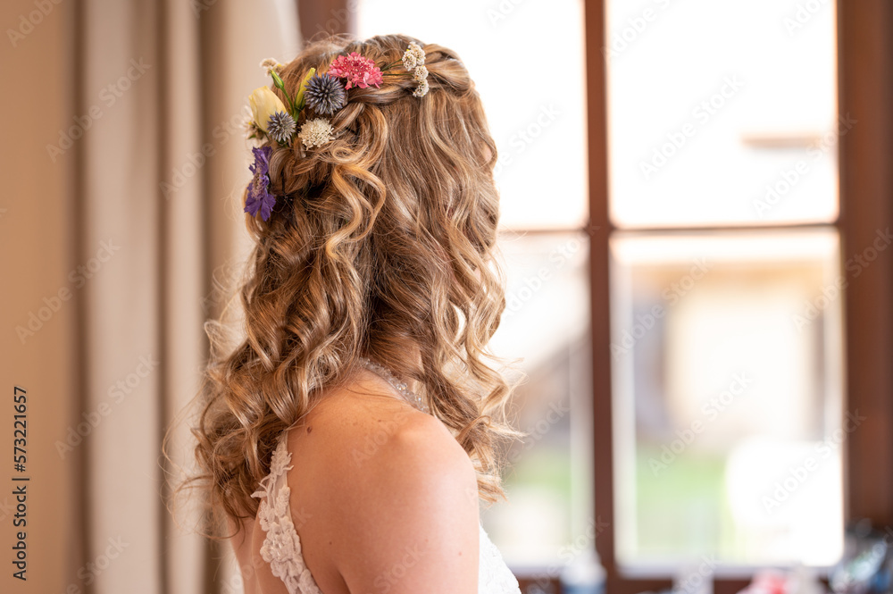Naklejka premium bride with long curly hair looking from window