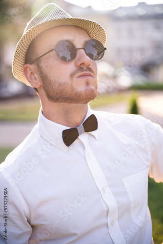 handsome presenter and showman in a stylish suit and hat with a microphone poses with the best emotions and acrobatic tricks