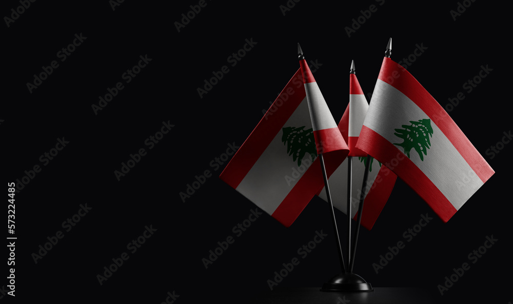 Obraz premium Small national flags of the Lebanon on a black background