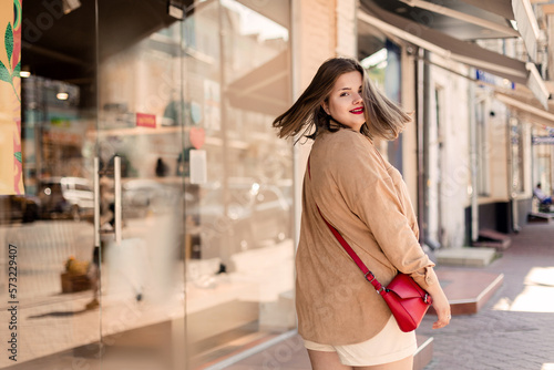 Gorgeous happy young woman plus size body positive walks in summer city center