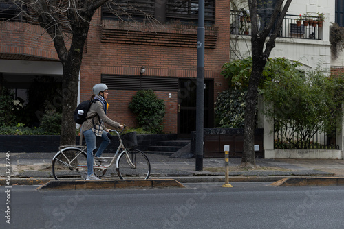 A young Latin American university student rides her vintage bicycle through the city.