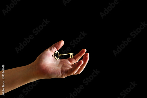 Vintage key levitates over the wizard's hand on a dark background photo