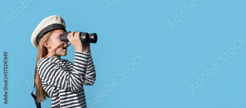 фотографія Banner-portrait of a sailor girl on a blue background teenage girl in a sailor suit with a binocular looking into the distance