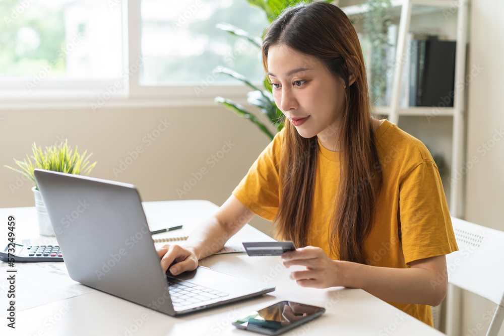 Internet banking, Online shopping at home, asian young woman hand in typing on keyboard, holding credit card, using laptop computer, spending money with purchase on store at home. Shopaholic ecommerce Internet banking, Online shopping at home, asian young woman hand in typing on keyboard, holding credit card, using laptop computer, spending money with purchase on store at home. Shopaholic ecommerce