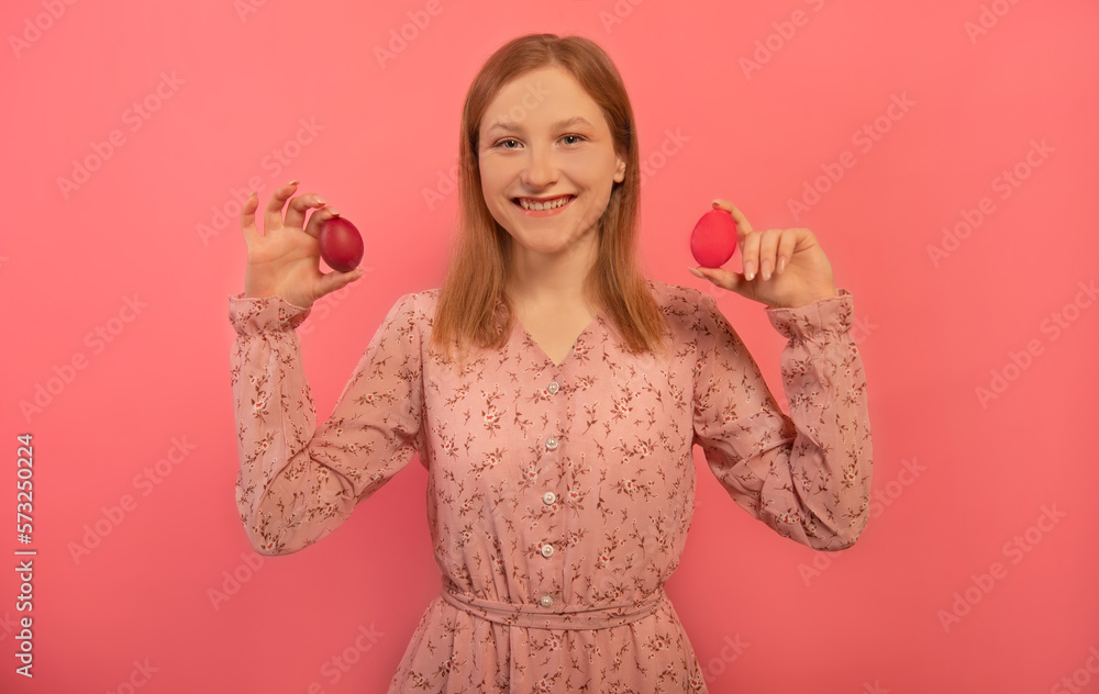 Happy smiling laughing girl holding two red painted easter eggs or showing dyed easter eggs, looking at camera and wearing pink floral dress isolated on pink background.
Easter Day or spring concept. Happy smiling laughing girl holding two red painted easter eggs or showing dyed easter eggs, looking at camera and wearing pink floral dress isolated on pink background.
Easter Day or spring concept.