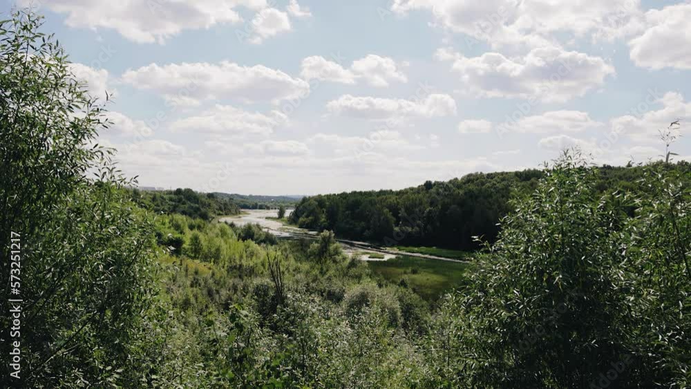 Shooting a beautiful landscape on the river bank. A small river flows among the trees and hills Shooting a beautiful landscape on the river bank. A small river flows among the trees and hills