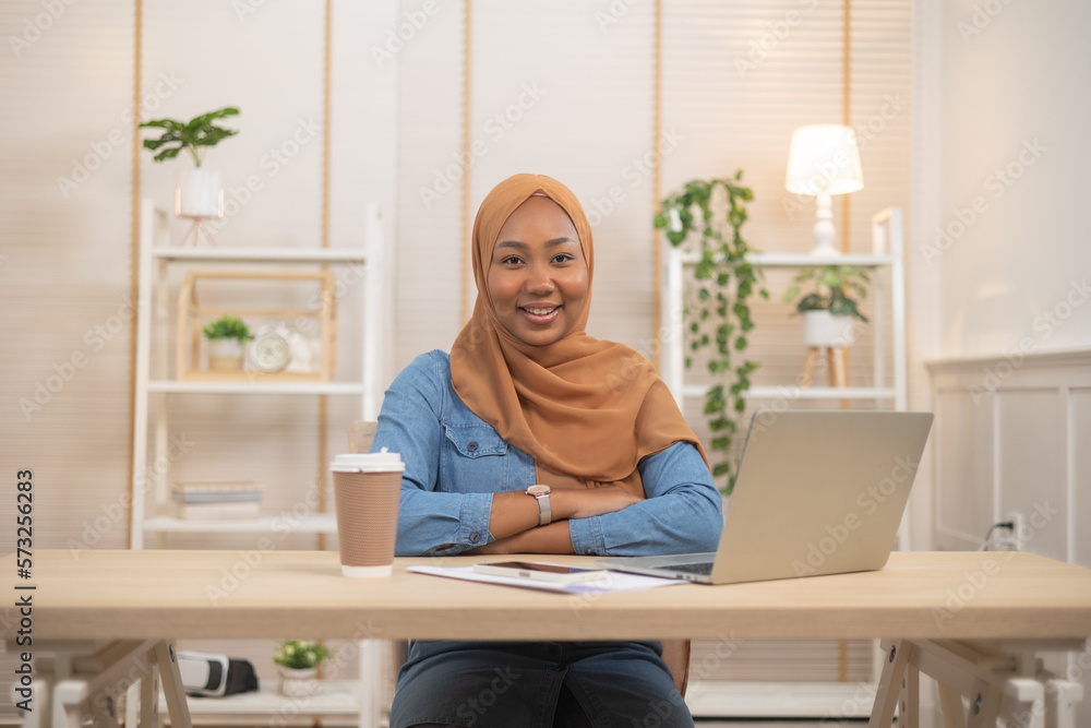 Portrait Of Young Black Muslim Woman In Hijab Using Laptop At Home .Work  at home concept.