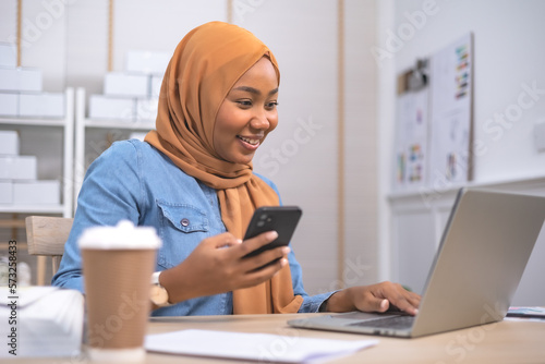 Smiling African female business owner using digital tablet and talking on the phone .Online shopping and start up concept.