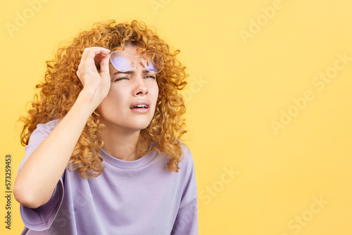 Woman taking off her glasses to see far away photo