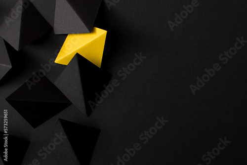 Black and yellow paper folded in geometric shapes. Think outside the box concept.