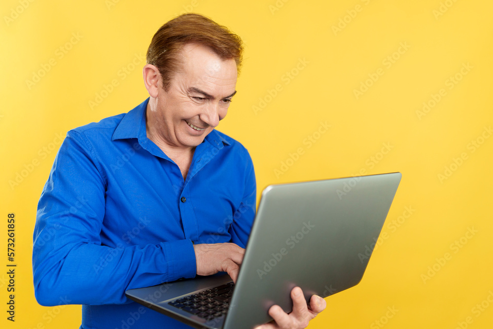 A happy mature man using a laptop