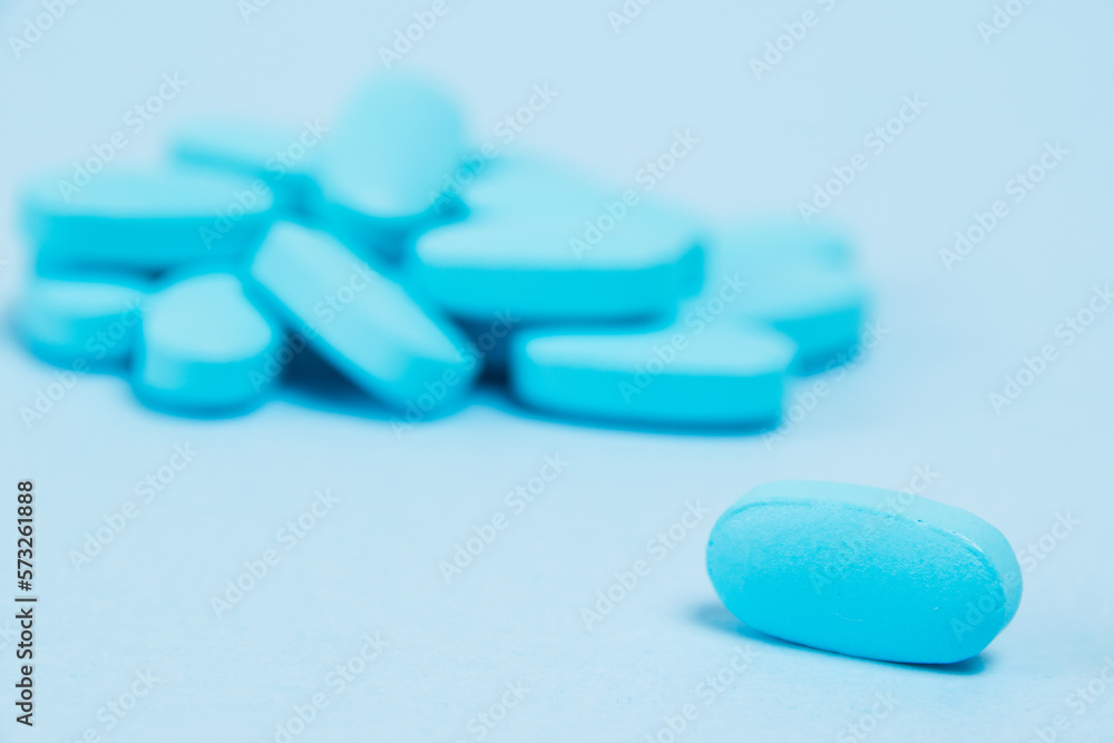 Many blue pills macro on paper background with copy space Many blue pills macro on paper background with copy space