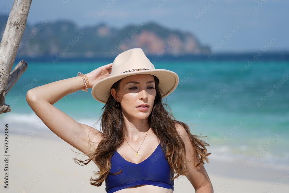 woman with a hat and bikini on the beach in krabi thailand, poda island, model shooting