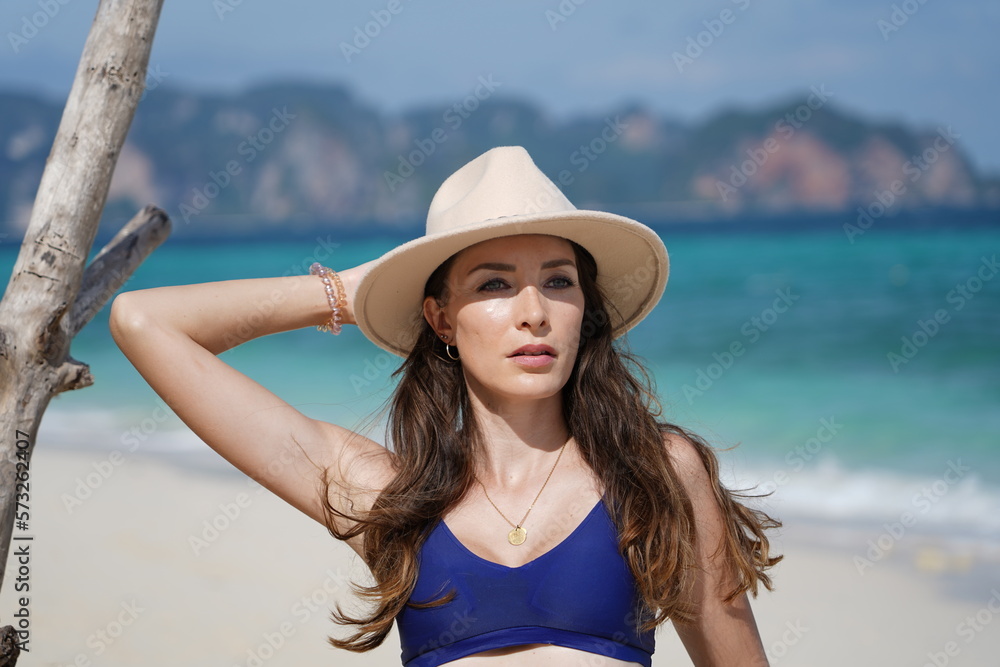 woman with a hat and bikini on the beach in krabi thailand, poda island, model shooting