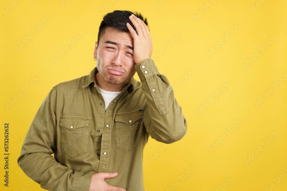 Chinese man gesturing bodily discomfort and headache Chinese man gesturing bodily discomfort and headache