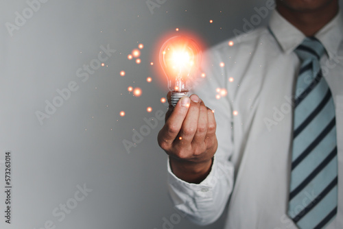 Businessman hand holding a light bulb. New ideas with technological innovation and creativity. with light bulbs that shine.