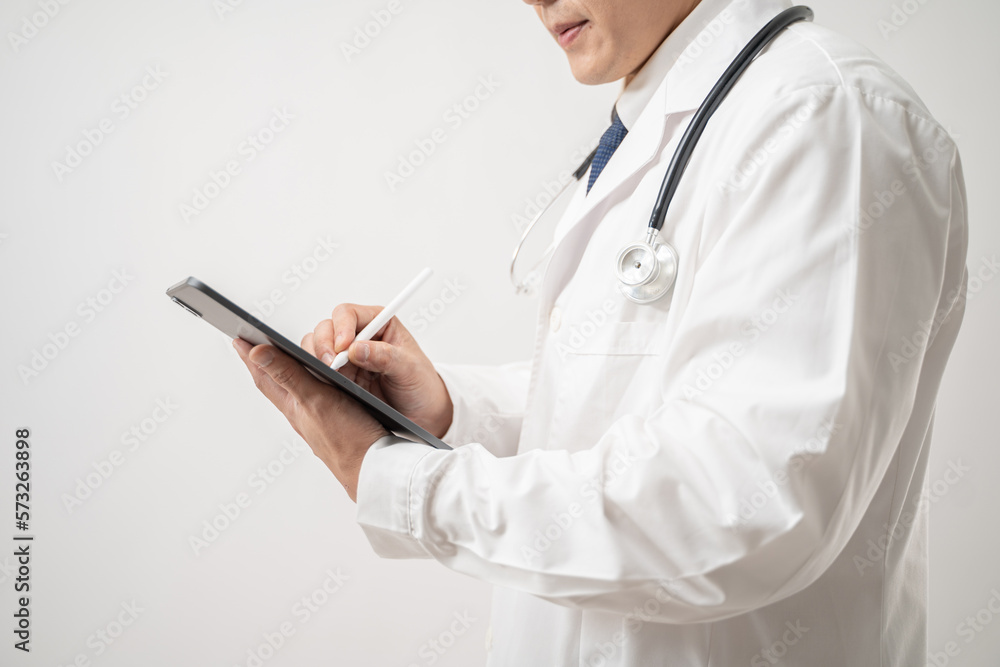 Portrait of confident Asian Doctor in glasses with stethoscope using a digital tablet isolated on white background Portrait of confident Asian Doctor in glasses with stethoscope using a digital tablet isolated on white background