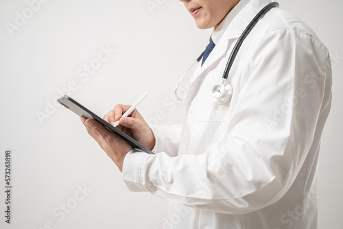 Portrait of confident Asian Doctor in glasses with stethoscope using a digital tablet isolated on white background