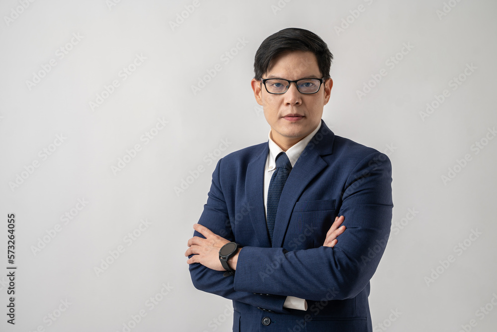 Portrait of confident Asian businessman in glasses standing with arms crossed on white background Portrait of confident Asian businessman in glasses standing with arms crossed on white background