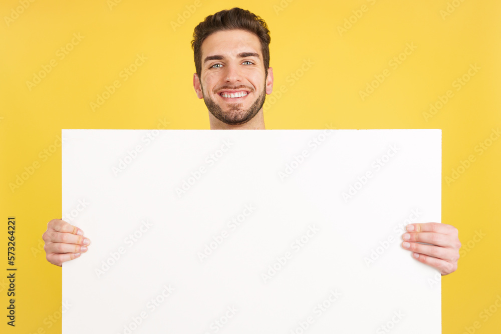 Happy caucasian man smiling while holding a blank panel Happy caucasian man smiling while holding a blank panel