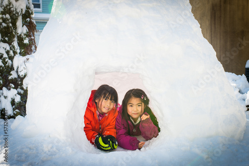 Young asian girl sitting inside igloo built after snow blizzard © Naomichi