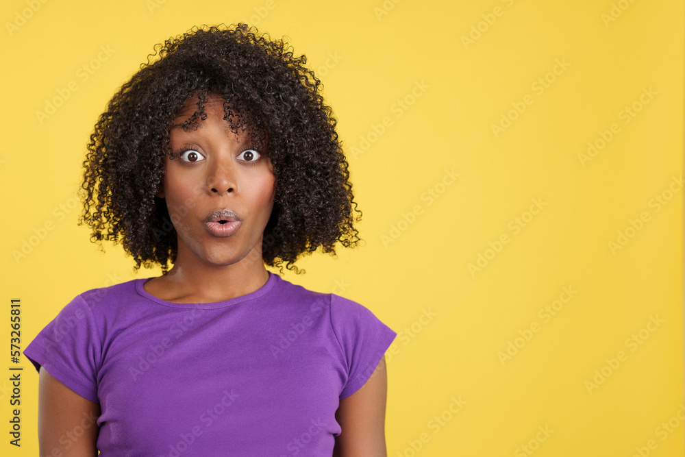 Shocked woman with afro hair looking at camera Shocked woman with afro hair looking at camera