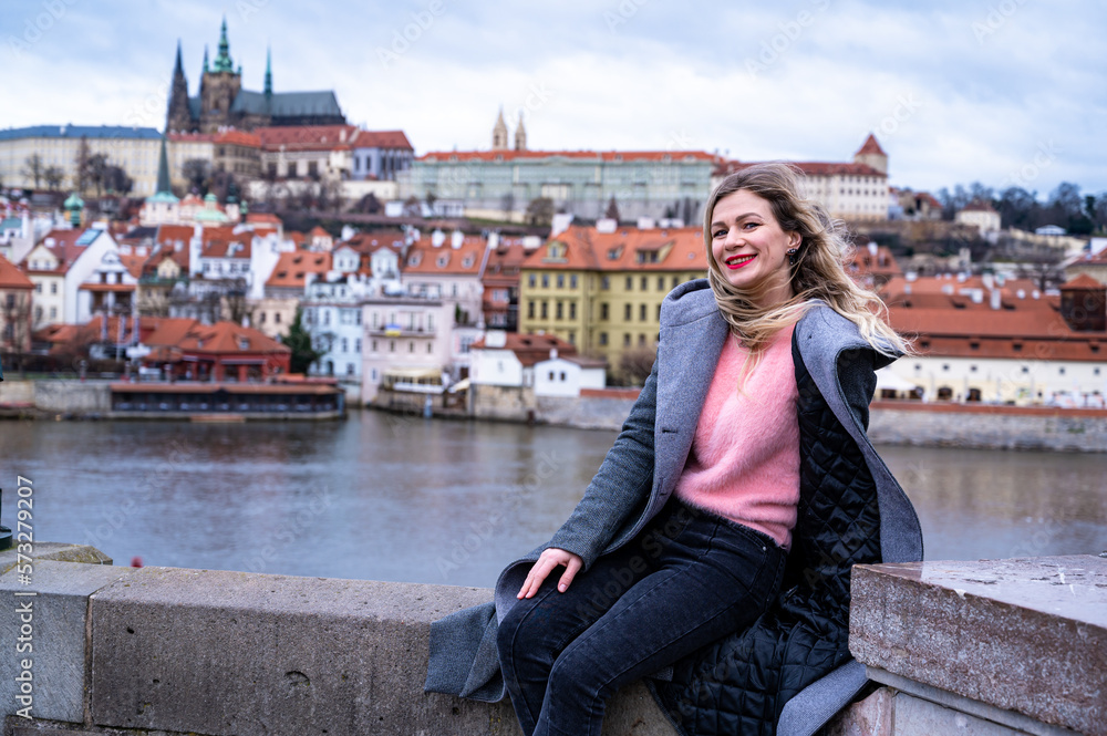 beautiful woman posing on the Charles Bridge on the background of Prague Castle                               