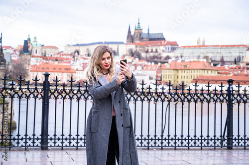 Photography A young female tourist in Prague takes a selfie photo to share online