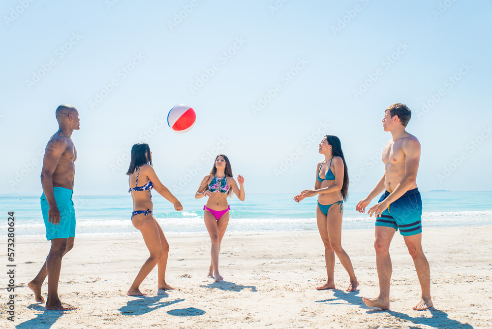 Happy multiethnic group of friends having summer vacation and having fun on the beach - Young people bonding together at the sea