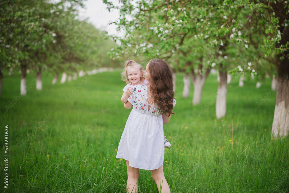 girl in the spring garden in bloom in spring with a child girl in the spring garden in bloom in spring with a child