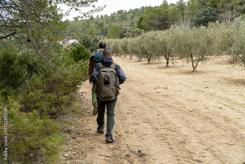 Three hikers walk through nature. 