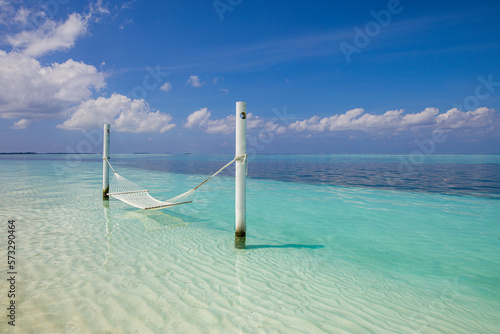 Relax vacation leisure lifestyle on exotic tropical island beach, aerial water hammock hanging calm sea. Paradise beach landscape tranquil carefree sunrise sky clouds amazing. Beautiful nature freedom
