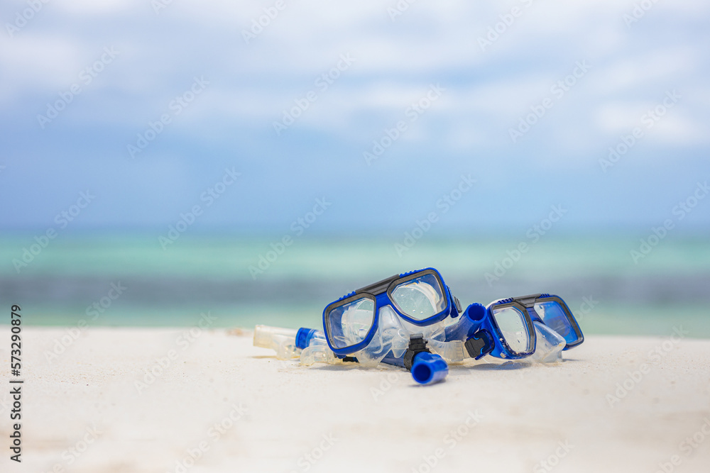 Summer sport beach activity, beach recreational concept. Diving goggles and snorkel gear on white sand near beach. Summer vacation and recreational travel adventure.  Outdoor sport wellbeing freedom