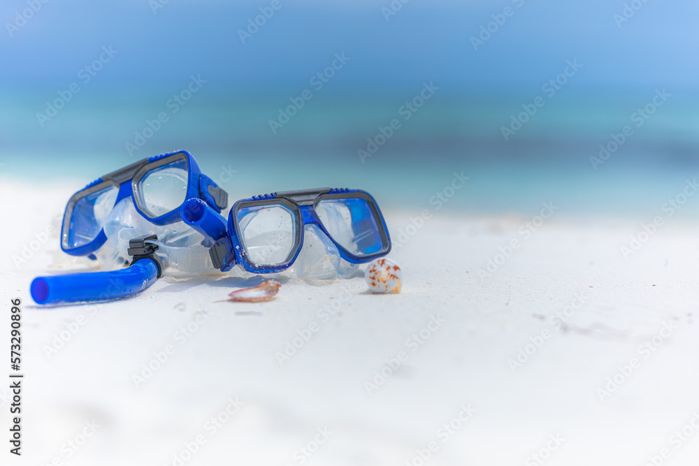 Summer sport beach activity, beach recreational concept. Diving goggles and snorkel gear on white sand near beach. Summer vacation and recreational travel adventure.  Outdoor sport wellbeing freedom