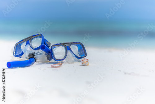 Summer sport beach activity, beach recreational concept. Diving goggles and snorkel gear on white sand near beach. Summer vacation and recreational travel adventure. Outdoor sport wellbeing freedom