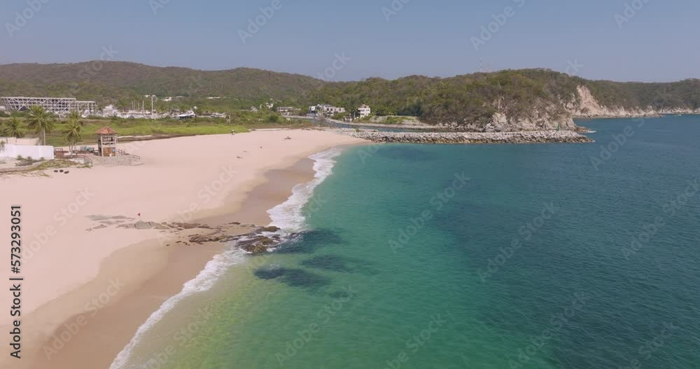 view of the beach. Aerial view of Chahué beach in Bahias de Huatulco Oaxaca. POV drone flies over tropical blue water—tourist attraction in summer vacation. view of the beach. Aerial view of Chahué beach in Bahias de Huatulco Oaxaca. POV drone flies over tropical blue water—tourist attraction in summer vacation.