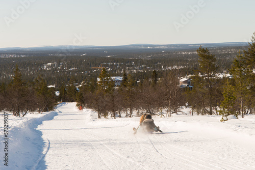 Behang Unrecognizable people sledding down a tobogganing run in Lapland
