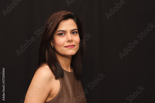 Portrait of smiling woman in brown top looking at camera.