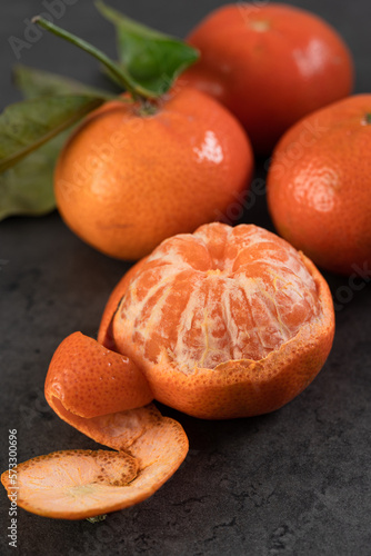 fresh tangerines with leaves on a dark background.